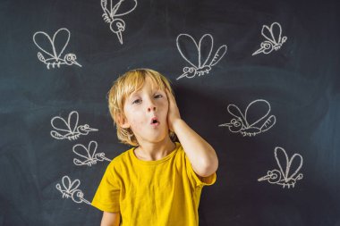 Komik yüz ifadesi ve gözümün önünde blackboard ile çizilmiş tebeşir sivrisinek sokması ile küçük çocuk. 