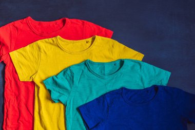 Ahşap arka plan üzerinde renkli koleksiyon t-shirtler