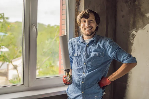 Mann Hält Schaumstoffwerkzeug Der Hand Und Lächelt Beim Fenstereinbau — Stockfoto