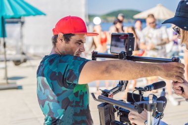 Profesyonel steadicam operatörü 3 eksenli kamera sabitleyici sistemi üzerinde bir ticari üretim dizi kullanır.