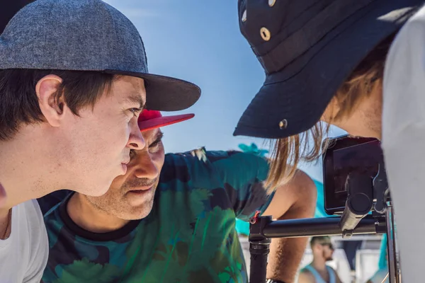 Operador de cámara, director de fotografía y director discuten el proceso de una filmación de vídeo comercial — Foto de Stock