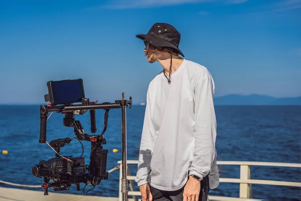 Professional steadicam operator uses a 3-axis camera stabilizer system on a commercial production set
