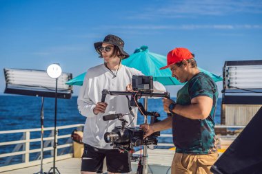 Steadicam Operatörü ve Yardımcısı bir ticari çekmek için kamera ve 3 eksenli sabitleyici-gimbal hazırlamak
