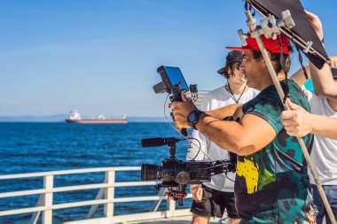 Profesyonel steadicam operatörü 3 eksenli kamera sabitleyici sistemi üzerinde bir ticari üretim dizi kullanır.