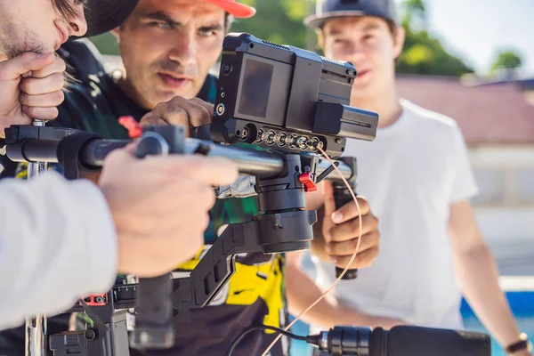 Steadicam opérateur et son assistant préparent caméra et stabilisateur-cardan 3 axes pour une prise de vue commerciale — Photo