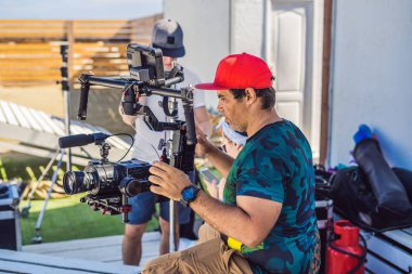 Steadicam Operatörü ve Yardımcısı bir ticari çekmek için kamera ve 3 eksenli sabitleyici-gimbal hazırlamak