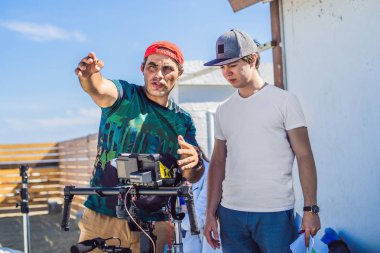 Steadicam Operatörü ve Yardımcısı bir ticari çekmek için kamera ve 3 eksenli sabitleyici-gimbal hazırlamak