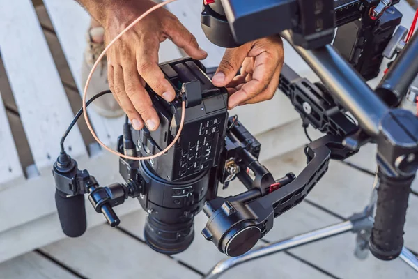 Schwebestativ-Bediener und sein Assistent bereiten Kamera und 3-Achsen-Stabilisator-Gimbal für ein Werbeshooting vor — Stockfoto