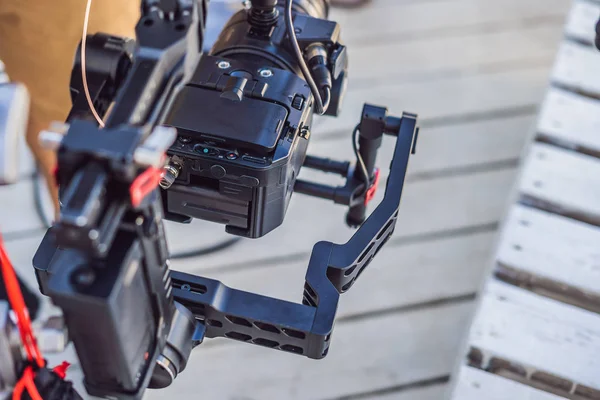 Operador Steadicam y su asistente preparan cámara y estabilizador-cardán de 3 ejes para un rodaje comercial —  Fotos de Stock