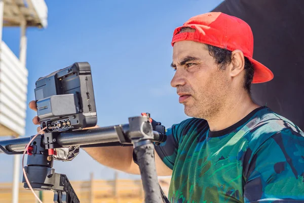 Steadicam operatore e il suo assistente preparare fotocamera e stabilizzatore a 3 assi-gimbal per uno scatto commerciale — Foto Stock