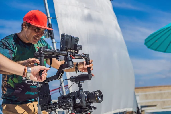 The production team on a commercial video shoot. Steadicam operator uses the 3-axis camera stabilizer and cinema-grade camera — Stock Photo, Image