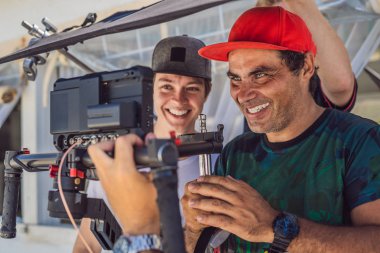 ticari bir klip çekimi üretim takımında. Steadicam Operatörü 3 eksenli kamera Sabitleyici ve sinema-grade kamera kullanır