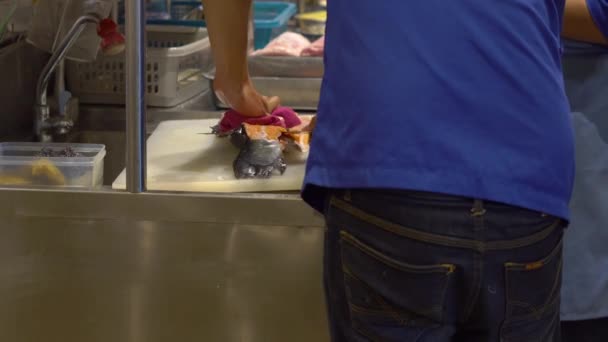 Steadicam záběr šéfkuchaře v japonské restauraci s otevřenou kuchyní, porážet, příprava filet z velkých lososů — Stock video