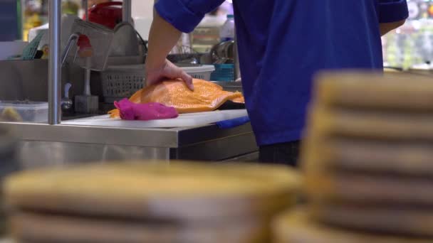 Foto Steadicam dari juru masak di restoran Jepang dengan dapur terbuka, menyembelih, menyiapkan fillet dari ikan salmon besar — Stok Video