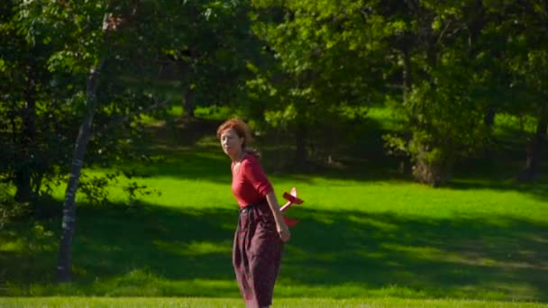 Père et fils dans un parc d'oiseaux nourrissent un perroquet rouge assis sur l'épaule des pères avec un lait — Video