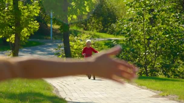 Filmagem em câmera lenta de uma jovem ensina seu filho a andar de bicicleta — Vídeo de Stock