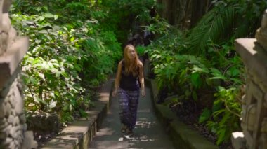 Genç bir kadın ve küçük oğlu maymun orman Eko park Ubud, Endonezya ziyaret Slowmotion atış