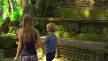 Genç bir kadın ve küçük oğlu maymun orman Eko park Ubud, Endonezya ziyaret Slowmotion atış