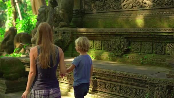 Filmagem em câmera lenta de uma jovem mulher e seu filho visitando o parque ecológico da floresta de macacos em Ubud, Indonésia — Vídeo de Stock