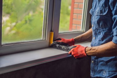 Pencere montaj sırasında kırmızı koruyucu eldiven giyen adam.