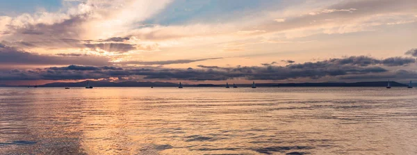 水の反射、空に雄大な雲と海に沈む夕陽。バナー、長い形式 — ストック写真