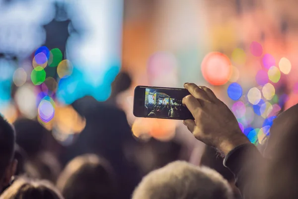 Use advanced mobile recording, fun concerts and beautiful lighting, Candid image of crowd at rock concert, Close up of recording video with smartphone, Enjoy the use of mobile photography