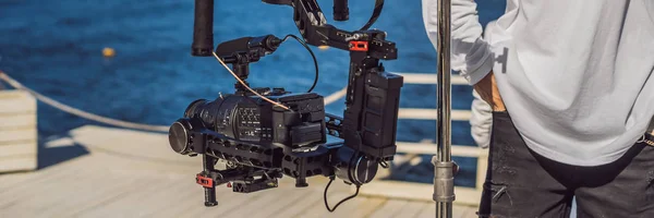 Câmera de cinema profeccional em um sistema estabilizador de câmera de 3 eixos em um conjunto de produção comercial BANNER, LONG FORMAT — Fotografia de Stock