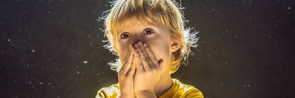Alergia al polvo. El chico estornuda porque es alérgico al polvo. El polvo vuela en el aire retroiluminado por la luz BANNER, FORMATO LARGO — Foto de Stock