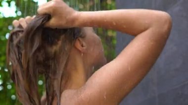 Genç kadın bir tropik bahçe duş alır.