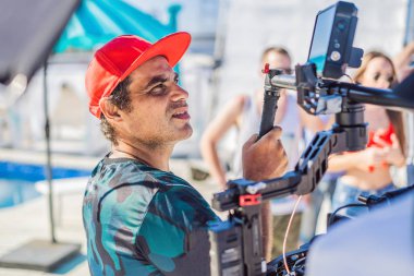 Profesyonel steadicam operatörü 3 eksenli kamera sabitleyici sistemi üzerinde bir ticari üretim dizi kullanır.