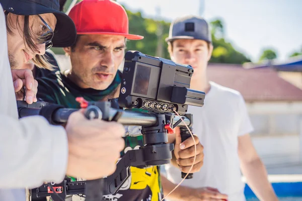 Operador Steadicam y su asistente preparan cámara y estabilizador-cardán de 3 ejes para un rodaje comercial —  Fotos de Stock