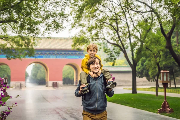 Papà e figlio sono turisti sullo sfondo delle grandi porte cinesi. Viaggiare con i bambini in Cina concetto — Foto Stock