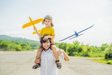 Mutlu baba ve oğul oyuncak uçak kırsal kesimde ile oynarken