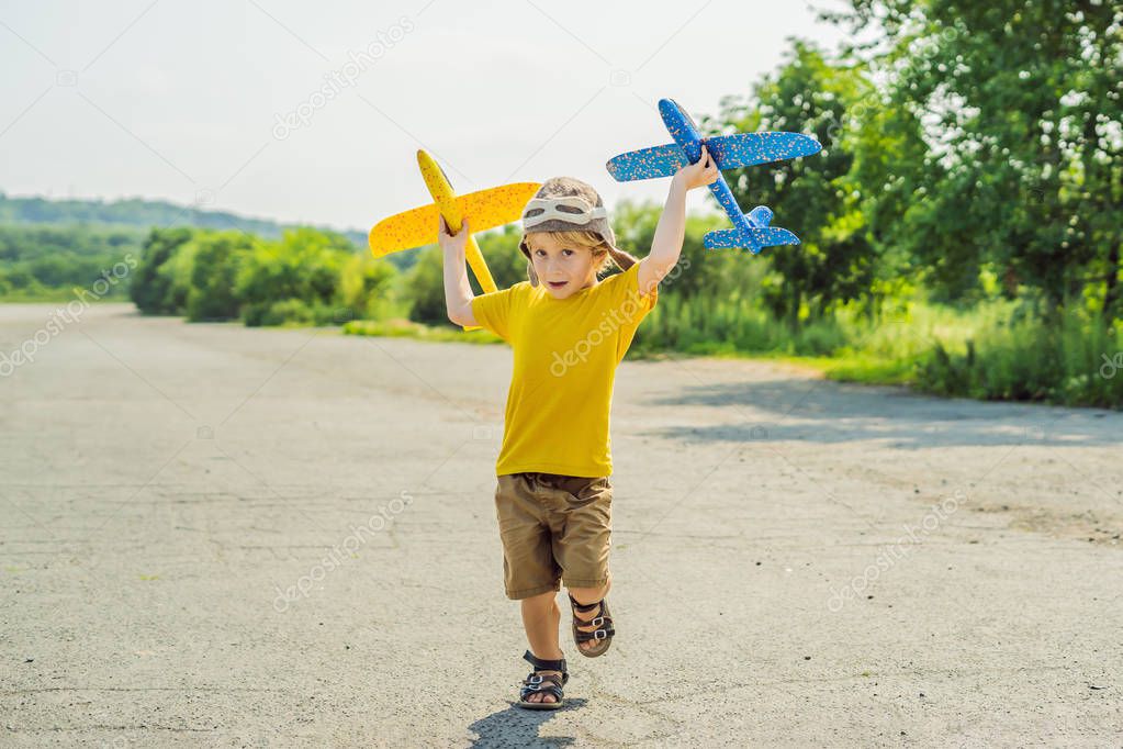 Happy kid playing with toy airplane against old runway background. Traveling with kids concept
