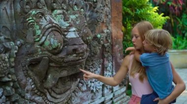 Güzel bir genç kadın ve küçük oğlu Puri Saren Kraliyet Sarayı Ubud köyde Bali adada ziyaret Slowmotion vurdu. Endonezya kavramı için seyahat. Çocuk kavramı ile seyahat