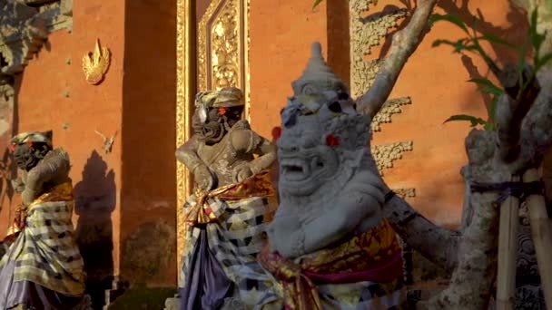 Captura en cámara lenta de estatuas de piedra dentro del Palacio Real de Puri Saren en el pueblo de Ubud en la isla de Bali. Viajes a Indonesia concepto — Vídeos de Stock