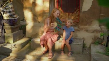 Güzel bir genç kadın ve küçük oğlu Puri Saren Kraliyet Sarayı Ubud köyde Bali adada ziyaret Slowmotion vurdu. Endonezya kavramı için seyahat. Çocuk kavramı ile seyahat.