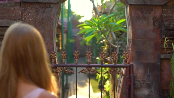 Fotografía en cámara lenta de una hermosa joven visitando el Palacio Real de Puri Saren en el pueblo de Ubud en la isla de Bali. Viajes a Indonesia concepto — Vídeos de Stock