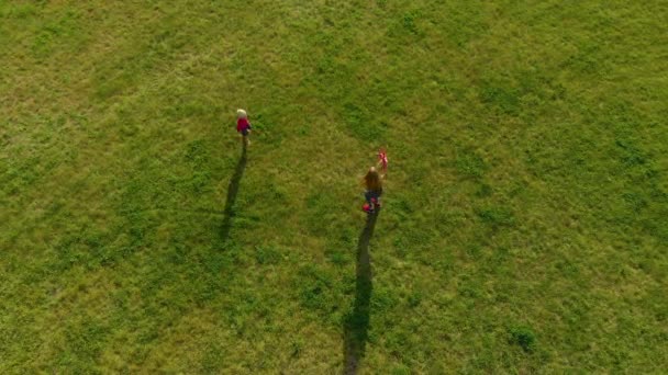 一个年轻女子和她的小儿子在公园里玩塑料飞机的空中镜头 — 图库视频影像