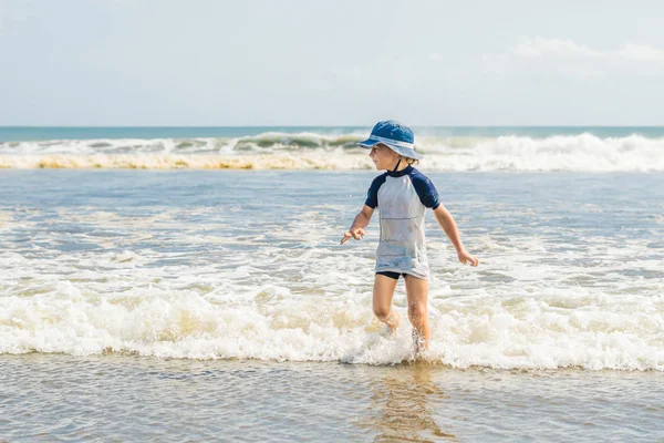 水のビーチで遊ぶ少年 — ストック写真