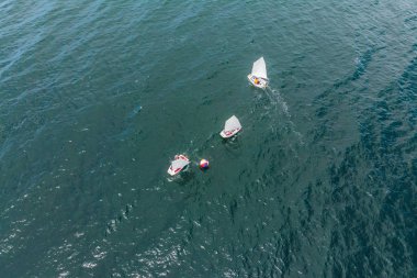 Gençler Akdeniz zümrüt denizde regatta yarışan küçük Yelkenli gemilerde hava uçak fotoğrafı