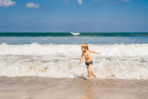 Jongen spelen op het strand in het water — Stockfoto