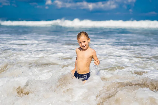 Garçon jouer sur la plage dans l'eau — Photo