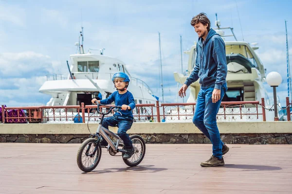 Baba oğul parkta Bisiklete binmeyi öğretir