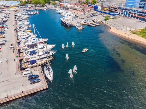 Foto aérea de drones de jóvenes adolescentes en pequeños veleros que compiten en la regata en el mar Mediterráneo esmeralda — Foto de Stock