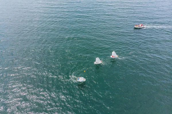 A fiatal tizenévesek, a kis vitorlás hajók a Regatta mediterrán smaragd tengeren versengő légi drone fénykép — Stock Fotó