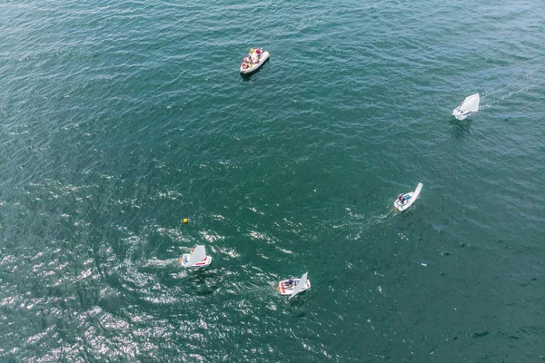 Luchtfoto drone foto van jonge tieners op kleine zeilboten concurreren in de regatta op mediterrane smaragdgroene zee — Stockfoto