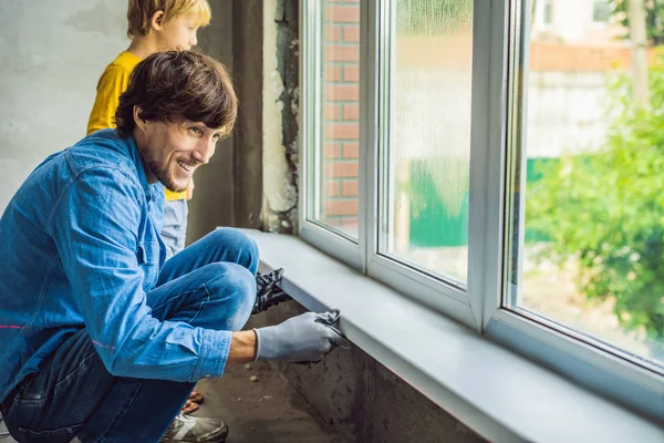 Father and son repairing windows together.