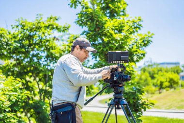 çekimden önce bir kamera ve bir tripod bir profesyonel kameraman hazırlar