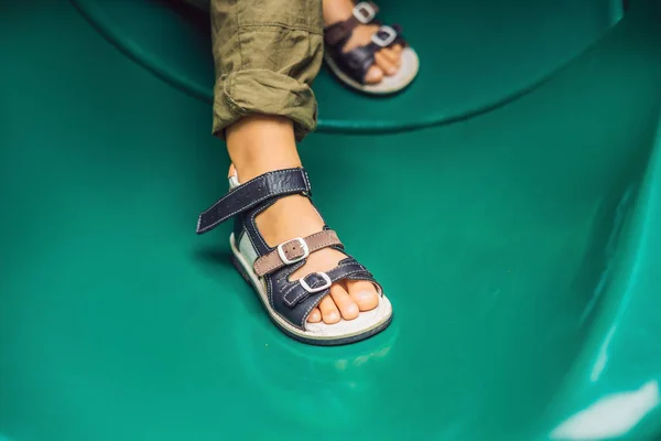 Menino Sandálias Ortopédicas Jogando Slide Verde Parque Infantil — Fotografia de Stock